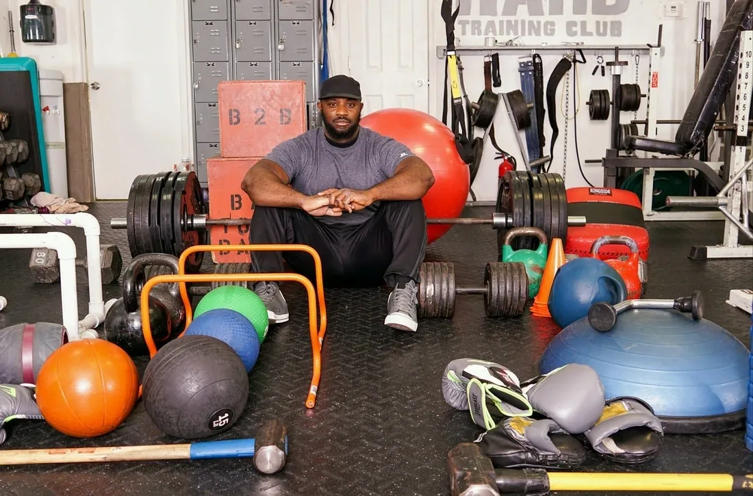 A man sitting on the floor in front of many different equipment.
