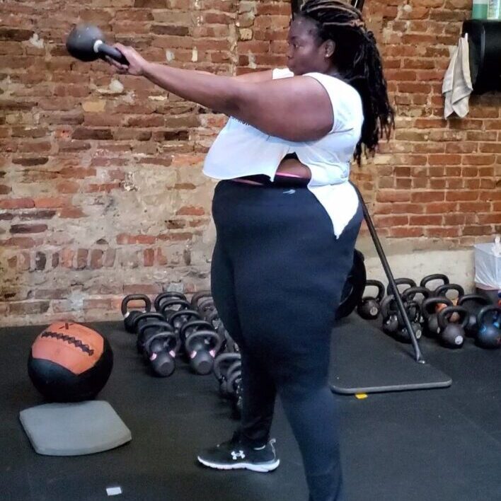 A woman is lifting a weight in the gym.